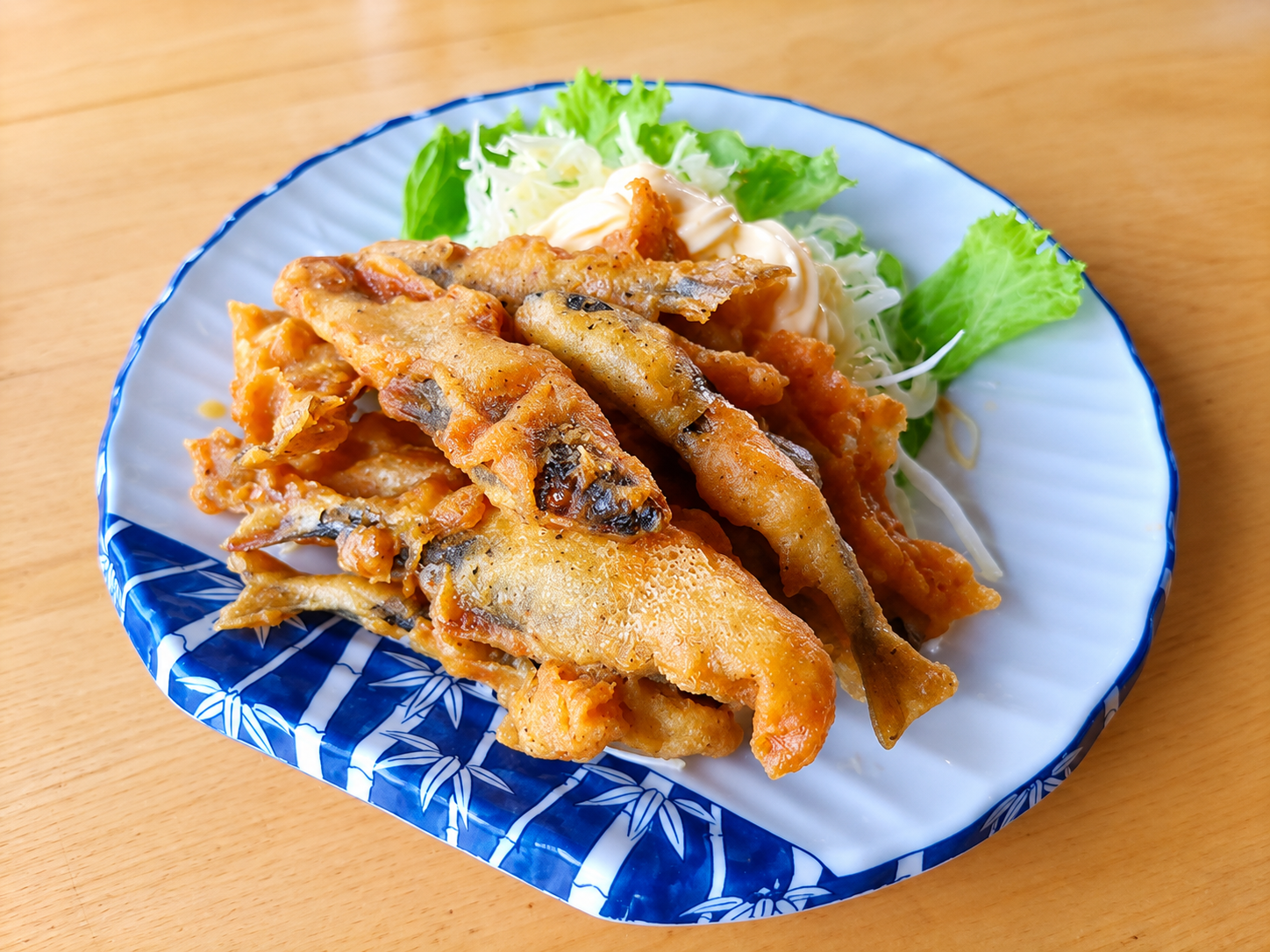 皿に盛られた稚鮎の唐揚げと千切りキャベツの付け合わせ
